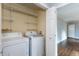 Bright laundry room features a washer, dryer, shelving, and a door to the rest of the house at 148 Murray Hill Ne Ave, Atlanta, GA 30317
