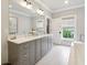 An elegant bathroom showcasing gray cabinetry, a double sink vanity, and a standalone tub for a spa-like experience at 3715 Peachtree Ne Rd # 2, Atlanta, GA 30319