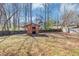 Fenced in backyard featuring mature trees and a small storage shed at 5508 Hadrian Ct, Lithonia, GA 30058