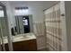 Bright bathroom featuring a vanity with a decorative mirror, bathtub with striped shower curtain at 601 Brass Key Ct, Lawrenceville, GA 30046