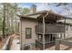 Exterior view of a brown-painted house with multiple porches surrounded by trees and natural vegetation at 1901 Cumberland Ct, Smyrna, GA 30080