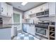 Well-lit kitchen featuring modern appliances, white cabinetry, and checkerboard flooring at 1901 Cumberland Ct, Smyrna, GA 30080