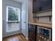 Bright wet bar featuring dark cabinets, butcher block countertop, beverage cooler, and window offering natural light at 1901 Cumberland Ct, Smyrna, GA 30080