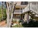 View of the exterior featuring decks and mature landscaping at 2135 N Forest Trl, Dunwoody, GA 30338