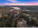 Scenic aerial view of luxury homes nestled among trees with beautiful lake views in the distance at 6455 Quiet Cove Rd, Cumming, GA 30041