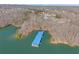 Aerial view of a covered boat dock on the serene lake, surrounded by lush greenery and waterfront properties at 6455 Quiet Cove Rd, Cumming, GA 30041
