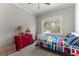 Bright bedroom featuring a window overlooking the outdoor landscape and playful decor at 6455 Quiet Cove Rd, Cumming, GA 30041