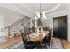 Open concept dining area, showing the table, chairs, light fixture, and staircase to the second floor at 6455 Quiet Cove Rd, Cumming, GA 30041