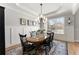 Bright dining room with wainscoting, a chandelier, and a large window offering natural light and neighborhood views at 6455 Quiet Cove Rd, Cumming, GA 30041