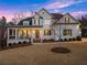 Inviting white brick home with a charming front porch and manicured lawn exudes classic elegance at 6455 Quiet Cove Rd, Cumming, GA 30041