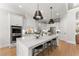 Modern kitchen showcasing a large island with seating, stainless steel appliances, and hardwood flooring at 6455 Quiet Cove Rd, Cumming, GA 30041