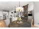 Open concept kitchen and living space featuring modern appliances, a large island and stone fireplace at 6455 Quiet Cove Rd, Cumming, GA 30041