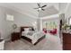 Primary bedroom with tray ceilings, carpet flooring, ceiling fan, with two lounge chairs near the window at 6455 Quiet Cove Rd, Cumming, GA 30041