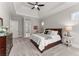Primary bedroom featuring carpet flooring, ceiling fan, tray ceiling and an ensuite bathroom at 6455 Quiet Cove Rd, Cumming, GA 30041