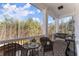 Inviting covered porch featuring brick flooring, a swing, and comfortable wicker seating with views of the lush surroundings at 6455 Quiet Cove Rd, Cumming, GA 30041