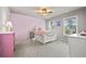 Bright bedroom with a pink accent wall, ceiling fan and two large windows at 654 Crystal Cove Ct, Loganville, GA 30052