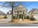 Two-story home featuring a charming front porch, manicured landscaping, and attached garage at 654 Crystal Cove Ct, Loganville, GA 30052