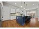 Modern kitchen features a blue island with seating, stainless steel appliances, and white cabinetry at 654 Crystal Cove Ct, Loganville, GA 30052