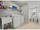 Functional laundry room with modern washer and dryer, a utility sink, and ample storage space at 654 Crystal Cove Ct, Loganville, GA 30052