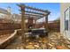 Inviting outdoor patio featuring brick fireplace under wood pergola, stone flooring and a wood fence at 654 Crystal Cove Ct, Loganville, GA 30052