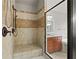 Close up of an oversized neutral tiled shower with bronze fixtures and bench seat at 654 Crystal Cove Ct, Loganville, GA 30052