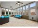Beautiful sunroom featuring bright blue sofas, travertine floors, many windows and a ceiling fan at 654 Crystal Cove Ct, Loganville, GA 30052