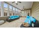 Bright sunroom featuring travertine floors, ceiling fans, and many windows providing abundant natural light at 654 Crystal Cove Ct, Loganville, GA 30052