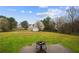 Spacious, fenced backyard with mature trees, flowering shrubs and a patio space with firepit perfect for outdoor enjoyment at 331 Cobblestone Rd, Auburn, GA 30011