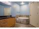 Bathroom featuring a wooden vanity with a black countertop and a tiled-in soaking tub at 204 Walker Sw St # 208, Atlanta, GA 30313