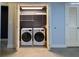 Convenient laundry closet with a stacked washer and dryer with extra storage shelves at 204 Walker Sw St # 208, Atlanta, GA 30313