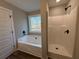 Bathroom featuring a soaking tub and separate shower with black fixtures at 494 West Ave, Bowdon, GA 30108