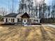 Charming home featuring a covered porch with timber accents and professionally landscaped flower beds at 494 West Ave, Bowdon, GA 30108