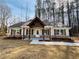 Charming home featuring a covered porch with timber accents and professionally landscaped flower beds at 494 West Ave, Bowdon, GA 30108