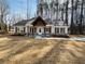 Charming home featuring a covered porch with timber accents and professionally landscaped flower beds at 494 West Ave, Bowdon, GA 30108