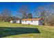 Large, white outbuildings located on a grassy property with large trees at 5692 Rock Patch Rd, Loganville, GA 30052