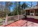 Red wooden deck with white railings and a grill, perfect for outdoor entertaining with views of the trees at 2426 Westland Way, Acworth, GA 30102