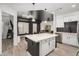 Contemporary kitchen featuring a center island with a stone countertop and adjacent living area with large windows at 200 River Vista Dr # 608, Atlanta, GA 30339