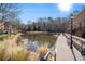 Scenic pond view with a brick walkway, lush landscaping, and nearby townhouses, providing a peaceful community setting at 200 River Vista Dr # 608, Atlanta, GA 30339