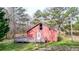 View of the back of the red home featuring a nice deck and pond in the background at 257 Crossroads Church Rd, Rockmart, GA 30153