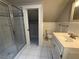 Well-lit bathroom featuring a glass shower, vanity, toilet, and neutral tile floors at 215 Buck Run, Loganville, GA 30052