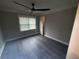 Well-lit bedroom featuring a modern ceiling fan, hardwood floors, and a window with blinds at 215 Buck Run, Loganville, GA 30052