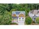 Aerial view of a home with beautiful landscaping, a gray roof and a long driveway surrounded by lush trees at 2717 Skyland Dr, Brookhaven, GA 30319