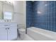 Modern bathroom featuring blue tiled shower-tub, white vanity, and sleek fixtures at 2717 Skyland Dr, Brookhaven, GA 30319