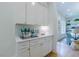 Butler's Pantry view features white cabinets with brushed gold hardware and marble backsplash at 2717 Skyland Dr, Brookhaven, GA 30319