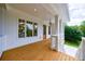 Relaxing front porch featuring wooden flooring, white columns, and a view of the lush greenery at 2717 Skyland Dr, Brookhaven, GA 30319