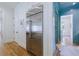 Hallway view with hardwood flooring, stainless refrigerator, and white trim at 2717 Skyland Dr, Brookhaven, GA 30319