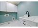 Well-lit laundry room with white cabinetry, modern faucet, and light blue walls at 2717 Skyland Dr, Brookhaven, GA 30319