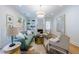 Light and airy living room with tufted sofa, modern light fixture, fireplace, and hardwood flooring at 2717 Skyland Dr, Brookhaven, GA 30319
