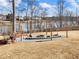 Spacious backyard featuring a fire pit area with seating, wood storage, and a serene lake backdrop at 6145 Stargazer Way, Cumming, GA 30028