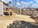 Expansive backyard featuring a wooden deck, fire pit area, lake view and fenced yard at 6145 Stargazer Way, Cumming, GA 30028